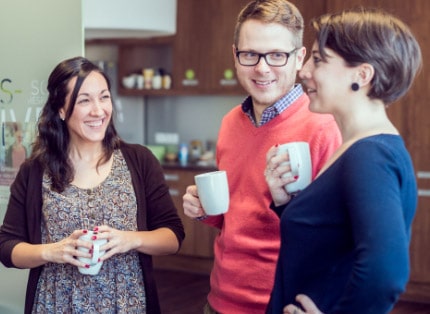 Four ADP employees holding coffee mugs